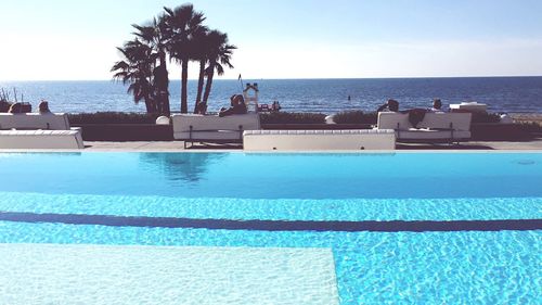 View of swimming pool by sea against clear sky