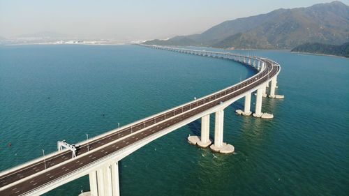 High angle view of bridge over sea against mountain