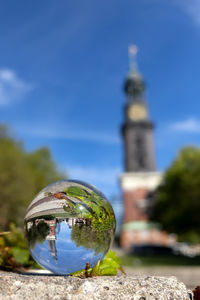 Close-up of crystal ball on tree against building