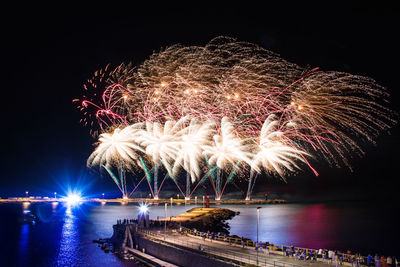 Firework display over river at night