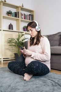 Young woman sitting on sofa at home