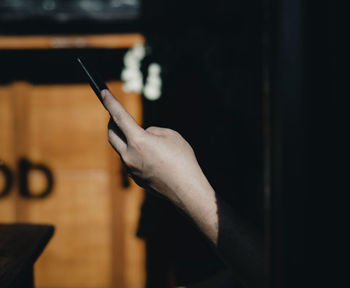 Midsection of man holding cigarette