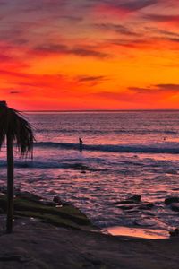 Scenic view of sea against orange sky