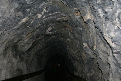 Rear view of woman standing in cave