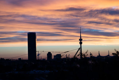 Silhouette buildings against sky during sunset