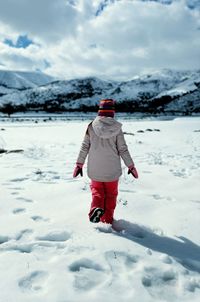 Rear view of boy standing on snow