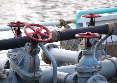 Pipes with valves on boat at lake