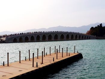 Wooden posts in river against clear sky