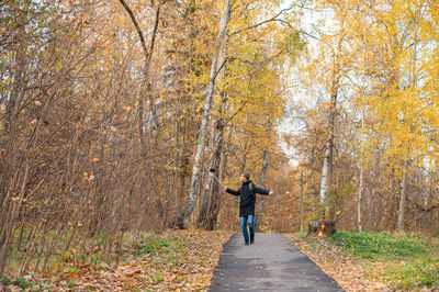 A teenage boy walks through an autumn park and shoots a video.  blogger. 