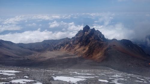 Scenic view of mountains against cloudy sky