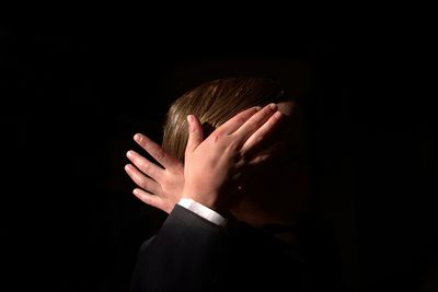 Close-up of human hand against black background