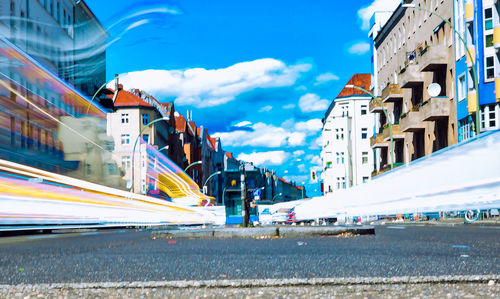 Cars on road by buildings against sky