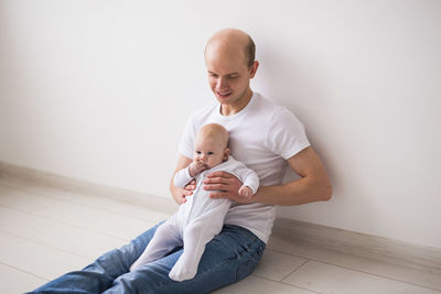 Father and baby sitting on table