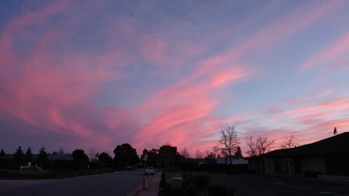 Silhouette of road against dramatic sky at sunset