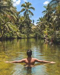 Rear view of shirtless man in water