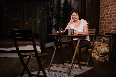 Woman sitting on table by bench