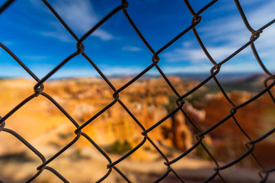 Close-up of chainlink fence against sky