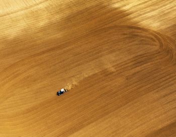 Aerial view of combine harvester moving on field