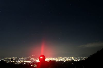 Low angle view of illuminated cityscape against sky at night