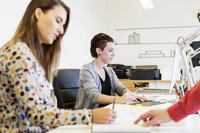 Design professionals working at desk in creative office