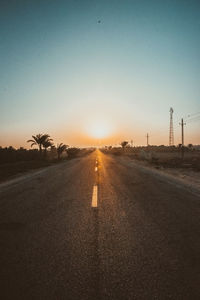Road against clear sky during sunset