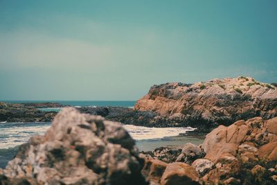 Rocks on beach against sky