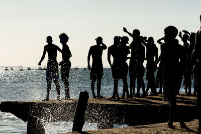  young people, in silhouette, are seen having fun on the crush bridge in the late afternoon 