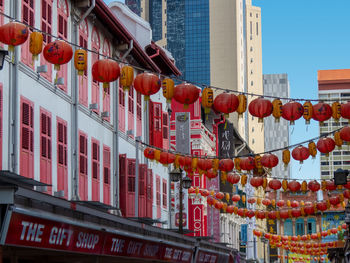 Low angle view of lanterns hanging amidst buildings in city