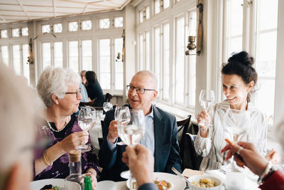 Senior friends with wineglass toasting in restaurant