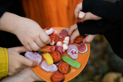 Halloween background. children's hands reach for the scary candy on the plate