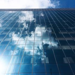 Low angle view of modern building against cloudy sky