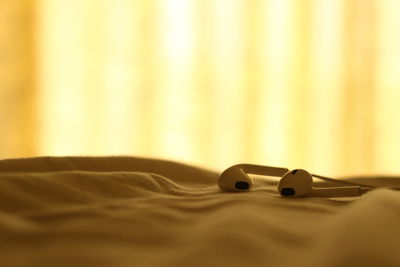 In-ear headphones on bed at home