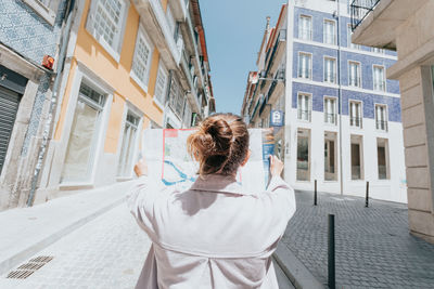 Rear view of woman standing against building