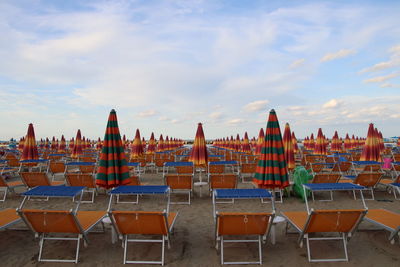 Panoramic view of chairs on beach against sky