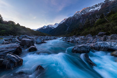 Scenic view of river amidst mountains against sky