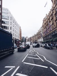 Cars on road in city against clear sky