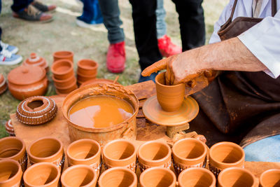 Midsection of man making clay pot at market