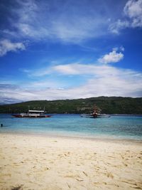 Scenic view of beach against blue sky