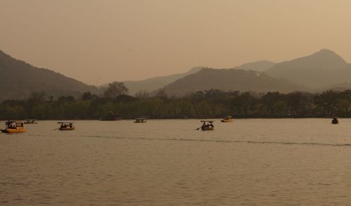 Scenic view of river by mountains against clear sky