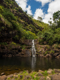 Scenic view of waterfall against sky