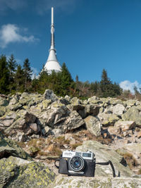 View of camera and rocks against sky