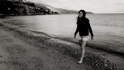 Portrait of young woman standing on mountain against sky