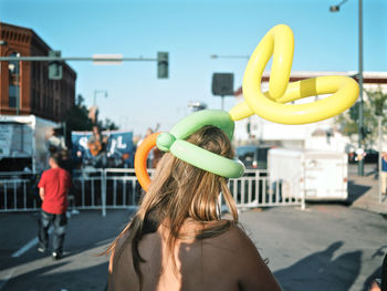 Rear view of women on street against sky