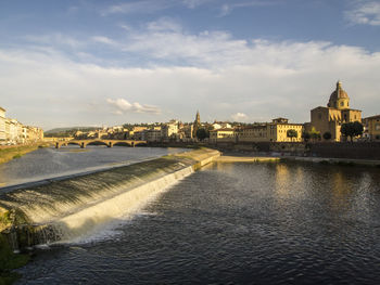 Bridge over river against buildings in city