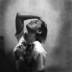 Portrait of young woman looking away against wall