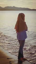 Rear view of woman standing on beach