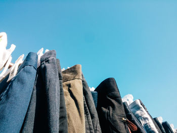 Low angle view of clothes hanging against clear blue sky