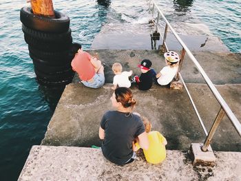 High angle view of people sitting by sea