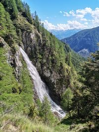 Scenic view of waterfall against sky