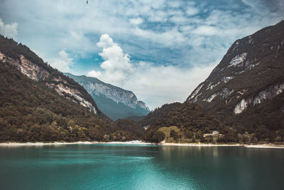 Scenic view of lake by mountains against sky